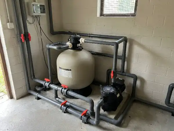 Filterpomp en zandfilter met pvc-leidingen in een technisch lokaal